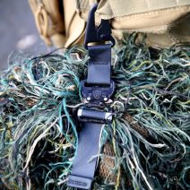 Tactical Attachment Strap in use photo, clipping a ghillie suit to a bag.